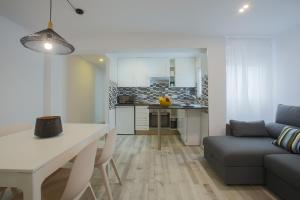 瓦伦西亚Apartment Meraki Valencia的厨房以及带桌子和沙发的客厅。