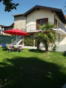 维韦罗内campeggio internazionale del sole的房屋前带椅子和遮阳伞的院子
