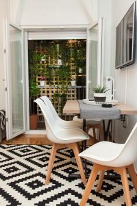 雅典Luxury Apartment In Central Kolonaki的一间带桌子和两把白色椅子的用餐室
