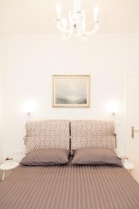 雅典Luxury Apartment In Central Kolonaki的一张位于白色房间的床,墙上挂着一幅画