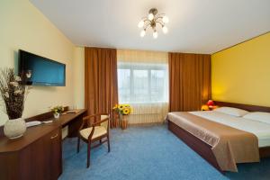 沃罗涅什乌克娜酒店的酒店客房配有一张床、一张书桌和一台电视。