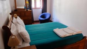 塔维拉Apartamento Tavira的一间卧室配有蓝色的床和蓝色椅子