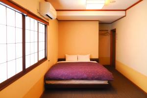 高山高山绿洲K之家旅舍的一间设有床铺的卧室,位于带窗户的房间内