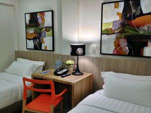 独鲁万Z帕德酒店的客房设有两张床和一张带台灯的书桌。