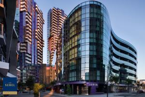 墨尔本The Sebel Melbourne Docklands Hotel的一座高大的玻璃建筑,在城市里