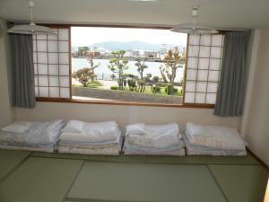 德岛港区民宿商务酒店的客房设有带一排枕头的窗户。