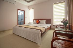 岑山Biệt thự Sao Biển - SB118 FLC Sầm Sơn Resort的一间卧室设有一张大床和一张玻璃桌