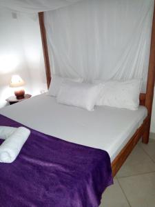 蒙巴萨Fast Care Villa Bavaria的一张带白色床单和枕头的床