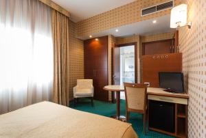 博洛尼亚米尔伦酒店的酒店客房配有一张床和一张书桌及一台电视