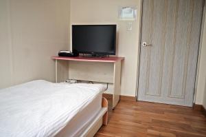 首尔江南亚韩旅馆的一间卧室配有一张床和一张桌子上的电视