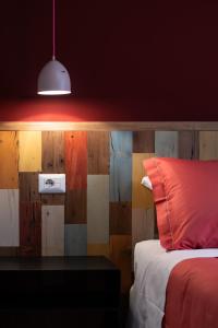基安蒂盖奥勒B&B L'Eroico的一间卧室配有一张床和一张带红色枕头的桌子