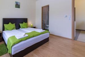 小克勒什Tölgyfa Vendégház的一间卧室配有一张带绿色枕头的大床