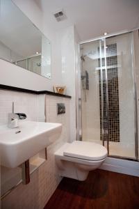 格拉斯哥The Spires Serviced Apartments Glasgow的一间带水槽、卫生间和淋浴的浴室