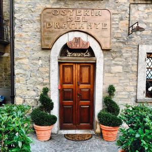 RoccaveranoAlbergo del Bramante的石头建筑中木门,有盆栽植物