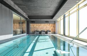 林雪平优质盒子酒店的一座带窗户的建筑中的游泳池