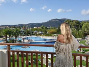 耶奥伊乌波利斯派洛特滨海度假酒店的站在泳池景阳台上的女人