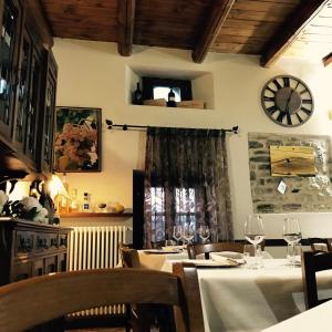 RoccaveranoAlbergo del Bramante的一间设有桌子和墙上时钟的餐厅