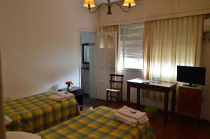 萨尔塔Hospedaje 371的客房设有两张床、一张桌子和一台电视。