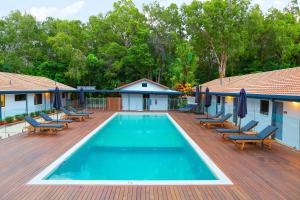 道格拉斯港Birch Resort Port Douglas的一个带躺椅的木制甲板上的游泳池