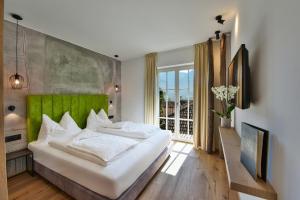 泰尔梅诺 金葡萄酒店的一间卧室配有一张大床和绿色床头板