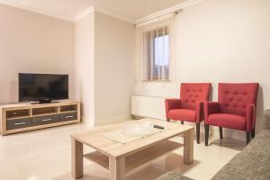 马林斯卡Luxury Apartments Villa Matea 1的客厅配有2把红色椅子和电视