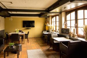 武夫斯根瓦尔德公园迎宾酒店的用餐室设有桌椅和窗户。