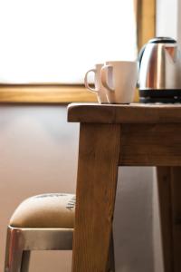 基安蒂盖奥勒B&B L'Eroico的一张带茶壶的木桌和一杯茶