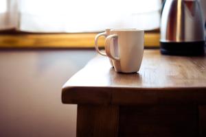 基安蒂盖奥勒B&B L'Eroico的坐在木桌边的咖啡杯
