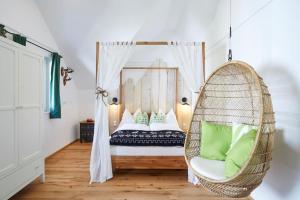 圣沃尔夫冈阿尔特格雷布勒雷精品公寓的配有一张挂椅的床的房间