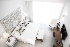赫索尼索斯阿巴顿岛度假村 的白色卧室配有白色的床和椅子