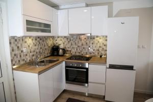 赫瓦尔Apartments Sunset的厨房配有白色橱柜和水槽