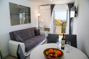 赫瓦尔Apartments Sunset的客厅配有沙发和带一碗水果的桌子