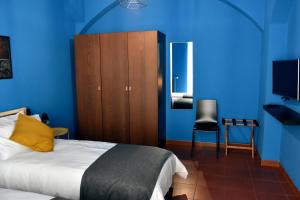 阿尔塔穆拉XVIII Arcano的一间卧室设有蓝色的墙壁和一张黄色枕头的床