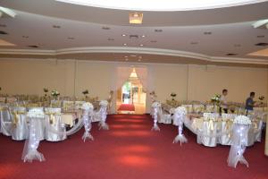 德巴尔维奈克酒店的宴会厅配有白色的桌子和白色的椅子