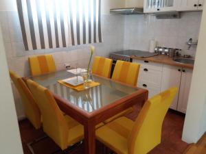 克拉古耶瓦茨Crystal Kragujevac的厨房配有玻璃桌和黄色椅子