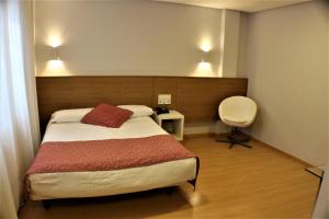 桑坦德欧洲之峰酒店的一间卧室配有一张床、一张桌子和一把椅子