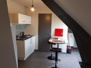 维尔Appartement Hyper centre - Quartier du château de Vire的厨房配有一张桌子,上面放着一台红色的笔记本电脑