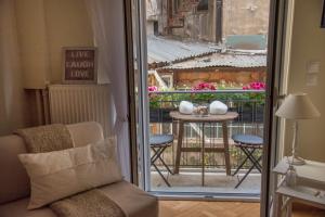 雅典Living near Acropolis by Sylvia Staikou的客房设有带桌子和窗户的阳台。
