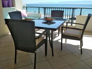 奥弗里安Luxury Sea View的阳台配有桌椅