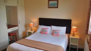 奎尔蒂Quilty Holiday Cottages - Type A的一间卧室配有一张带两盏灯的大型白色床。