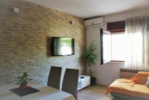 布拉采Apartments Villa Judita的客厅设有餐桌和砖墙