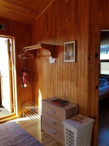Lagarfljótsvirkjun埃克拉小屋酒店的卧室设有木墙、一张床和一个梳妆台