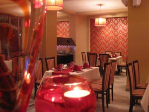 德巴尔维奈克酒店的用餐室配有桌椅和蜡烛
