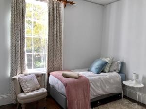 Sassafras罗宾汉韦尔农家乐的一间卧室设有一张床、一个窗口和一把椅子