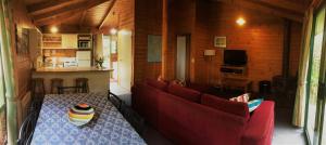 比舍诺鹬海洋别墅酒店的客厅配有桌子和红色沙发