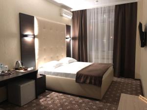陶里亚蒂Chocolate Hotel的一间卧室配有一张床、一张书桌和一个窗户。