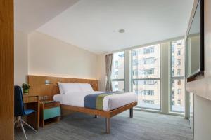 香港峰景轩的酒店客房设有一张床和一个大窗户