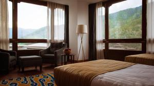 廷布不丹廷布沃瑟酒店的酒店客房带一张床、椅子和窗户