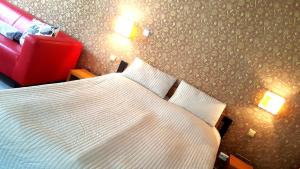 洛乌尼梅洛酒店的一间卧室配有一张床和一张红色椅子