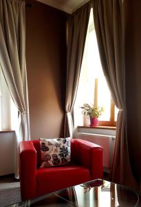 洛乌尼梅洛酒店的客厅里的一个红色椅子,有窗户
